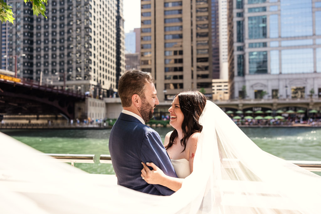 Creative photo of bride and groom standing near the river in downtown Chicago framed by the bride's flowing veil