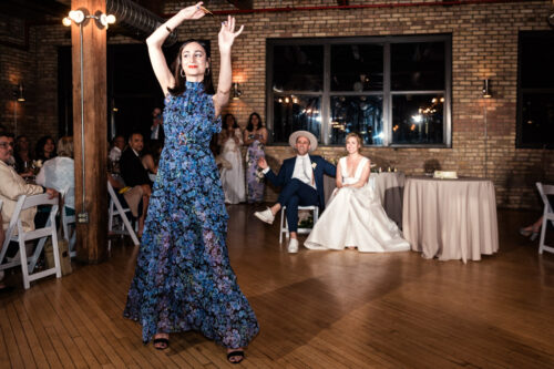 Guest dances at a wedding reception, while the bride and groom watch and smile during wedding reception at The Hive on Hubbard in Chicago