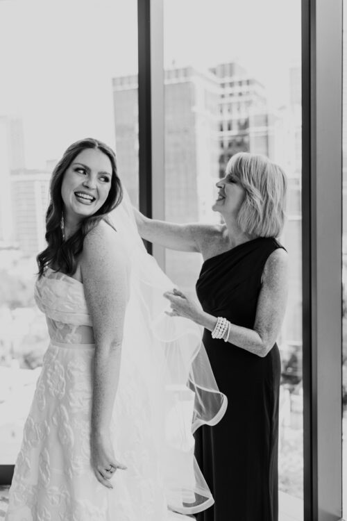 Bride smilies as her mother helps with her veil while getting ready at Viceroy Chicago before her Lincoln Park wedding