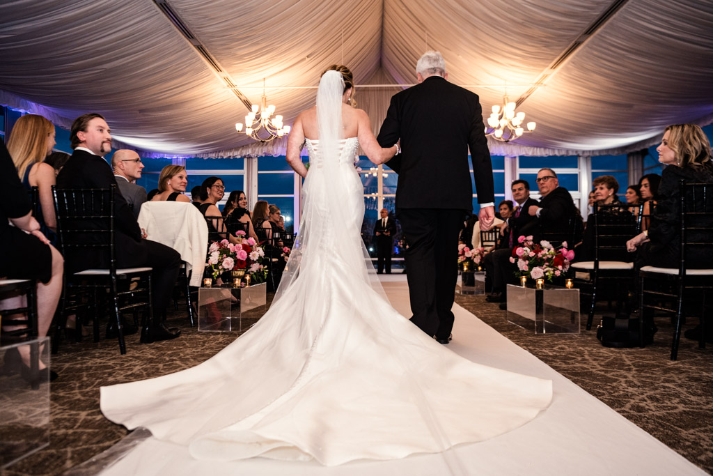 Bride walking down the aisle with her father, surrounded by seated guests during Lincolnshire Marriott Resort wedding ceremony
