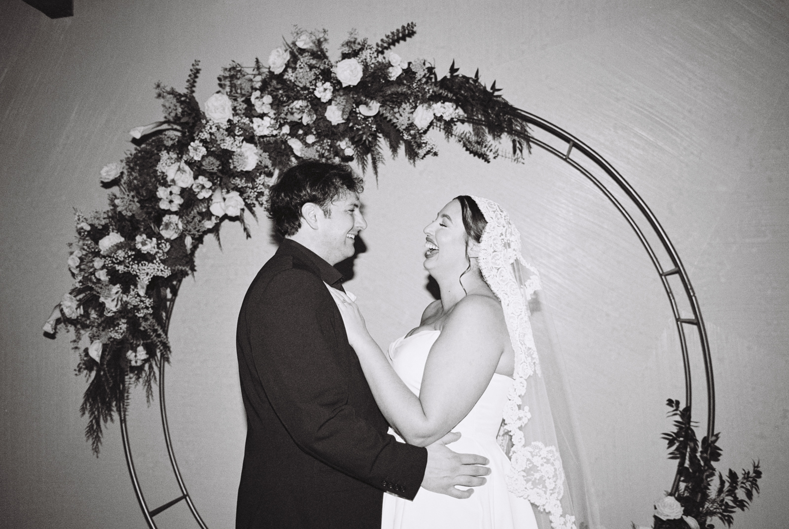 Candid photo of bride and groom laughing at their Walden Chicago winter wedding captured on black and white film