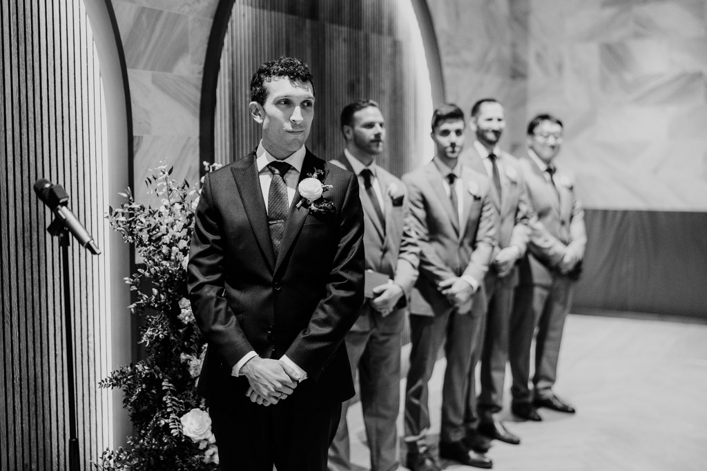 Black and white photo of groom standng with his groomsmen, waiting for the bride during their Chicago Winery wedding ceremony