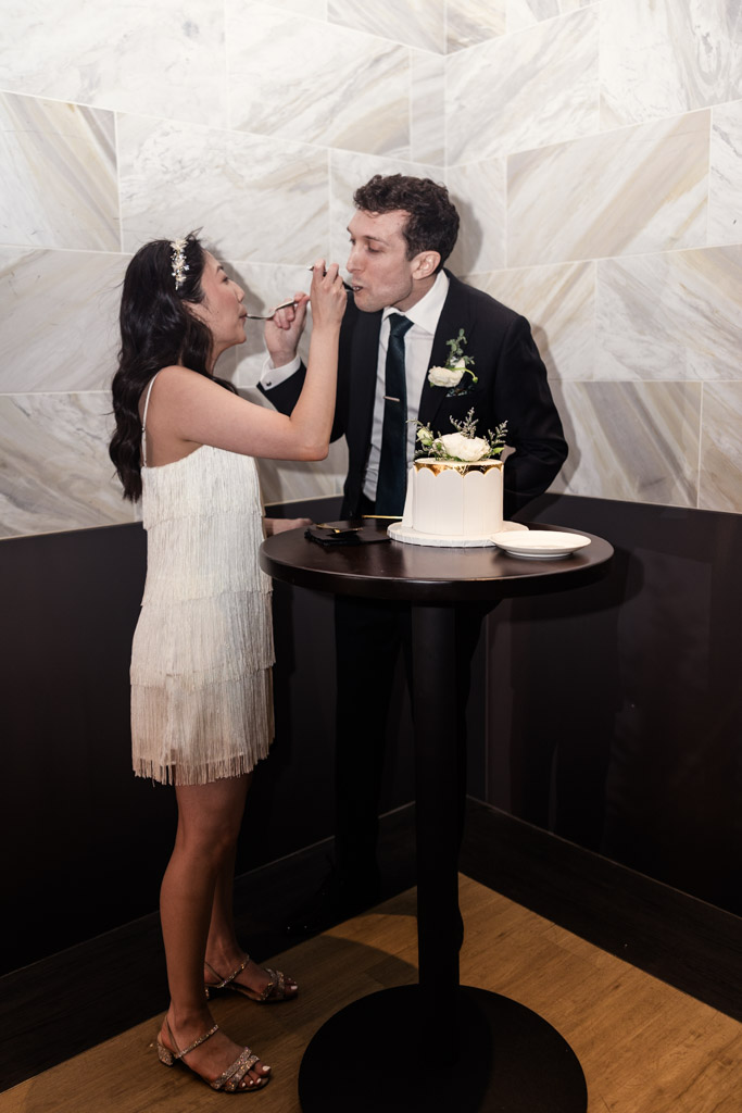 Newlyweds feed each other cake during their wedding reception at Chicago Winery