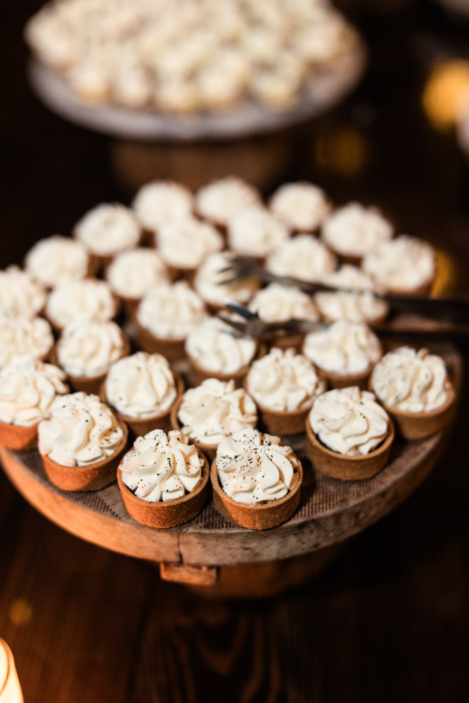 Tray of desserts displayed on a wooden stand with serving tongs for Chicago Winery wedding reception