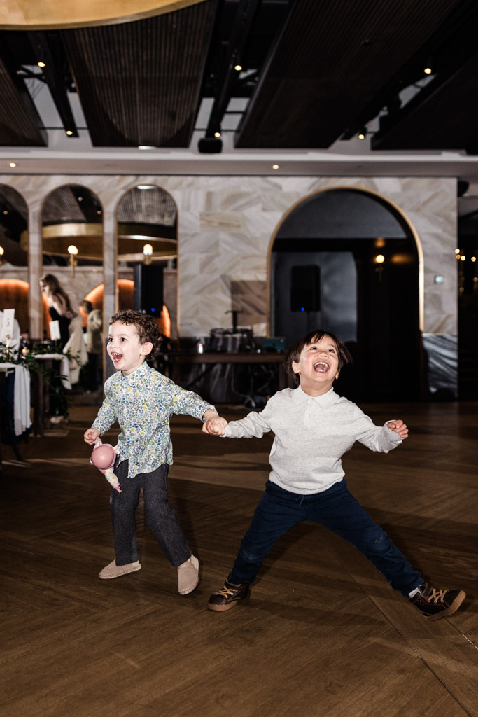Two young children laughing and holding hands while dancing at Chicago Winery wedding reception