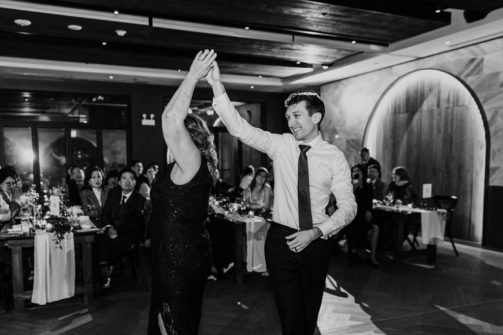 Black and white photo of groom twirling his woman on the dance floor at Chicago Winery wedding reception