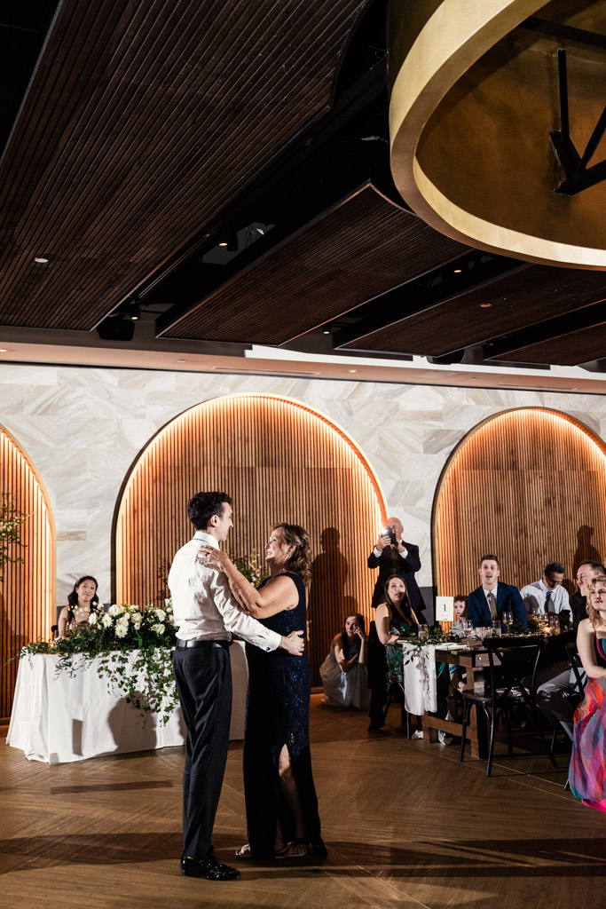 Groom dances with his mother during Chicago Winery wedding reception as guests watch and smile