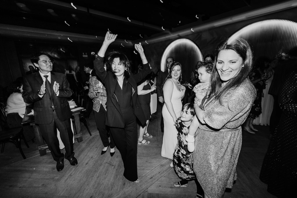 Black and white photo of people dancing and smiling during wedding reception at Chicago Winery