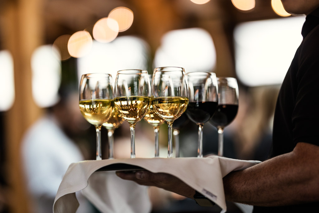A server holds a tray with glasses of white and red wine for Chicago Winery wedding reception