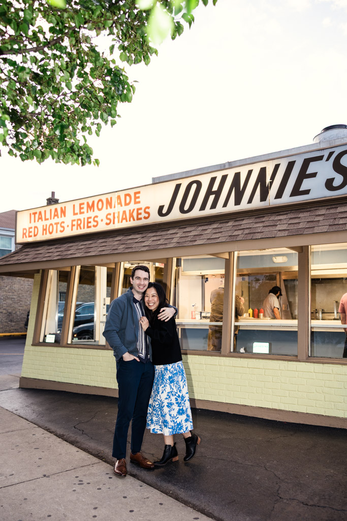 Engaged couple hugs outside Johnnie’s Beef in Oak Park
