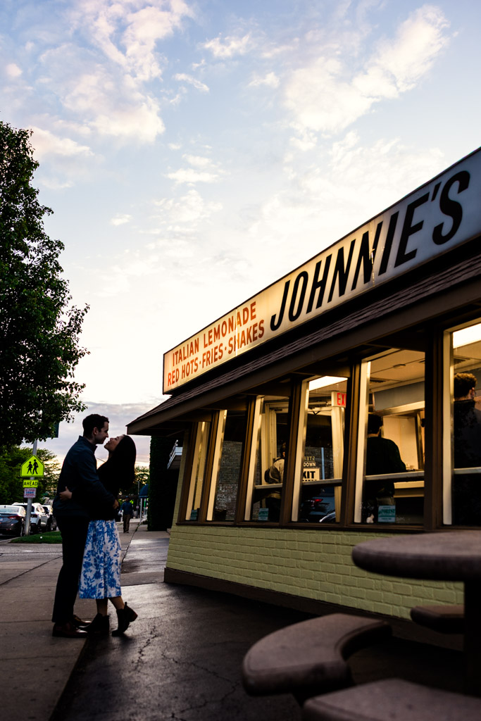 A couple shares a quiet moment outside Johnnie'sBeef at sunset, during their Oak Park engagement session