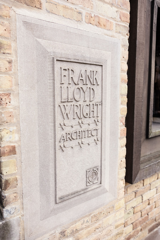 Engraved stone plaque on a brick wall reading