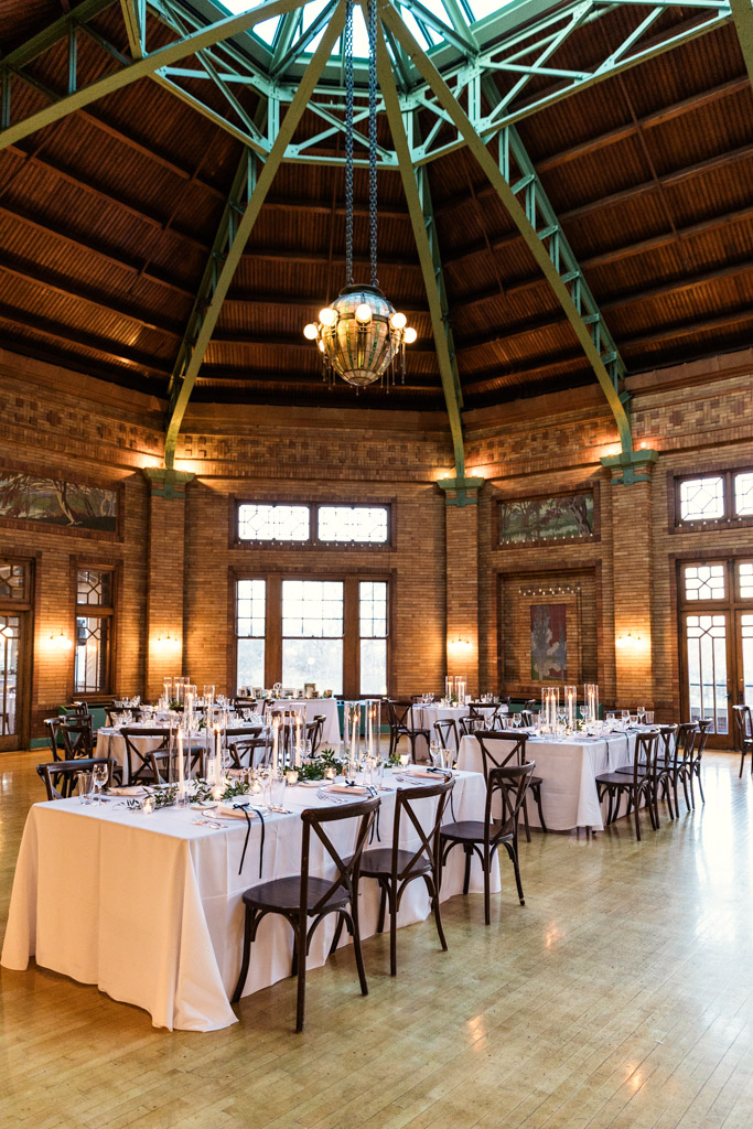 Cafe Brauer wedding reception space featuring round and rectangular tables under a large skylight