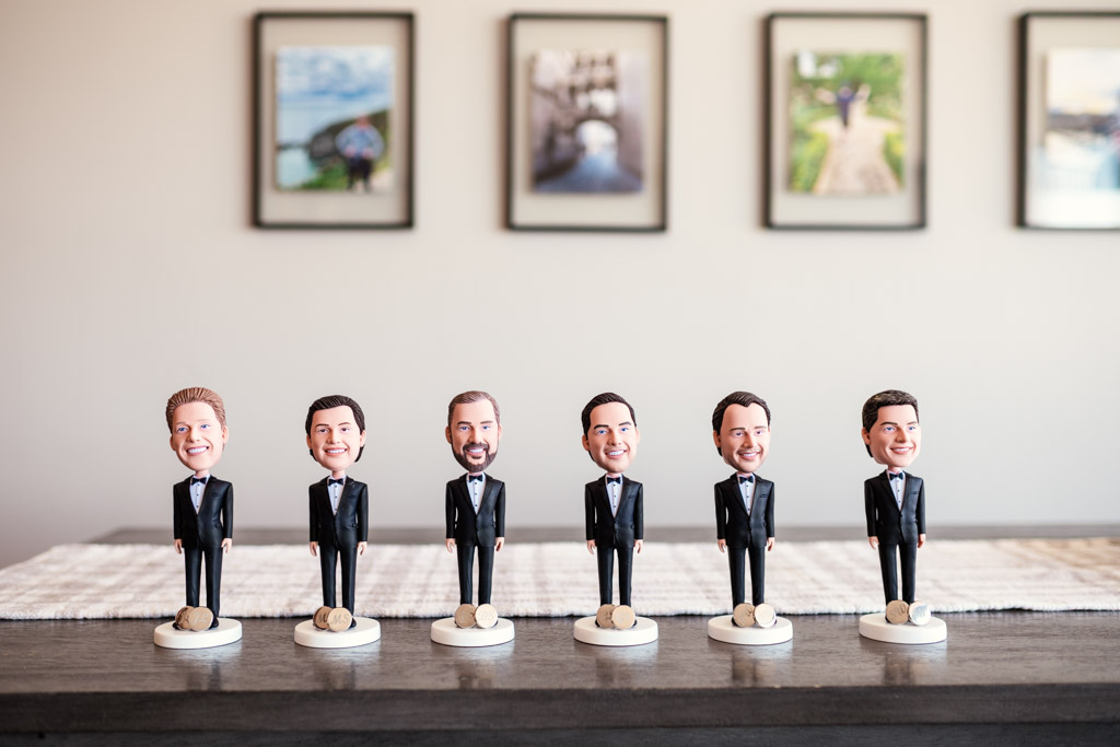 Custom commemorative bobbleheads for the groomsmen lined up on a table inside the bride and groom's apartment