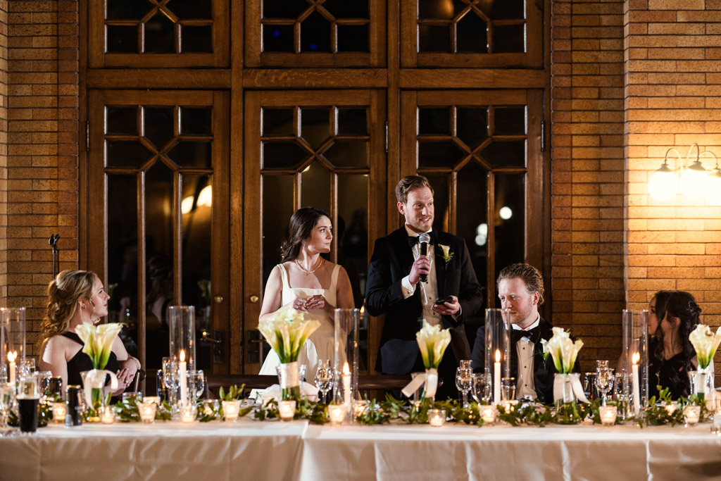 Bride and groom give speech from the head table during Cafe Brauer wedding reception
