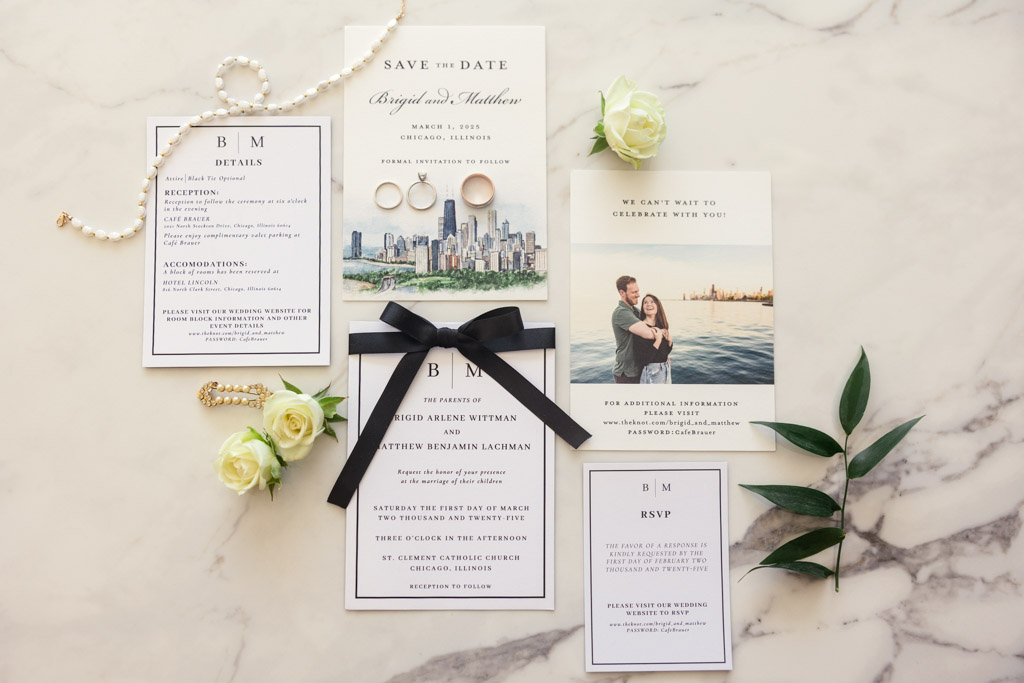 Wedding invitation suite with floral decor, pearl necklace, and RSVP cards arranged on a marble surface for spring Lincoln Park wedding celebration