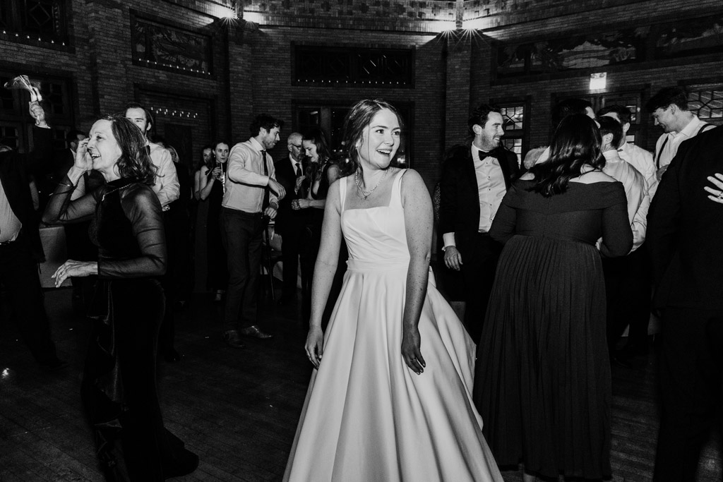 Bride in a white gown smiles on the dance floor during her Cafe Brauer wedding reception
