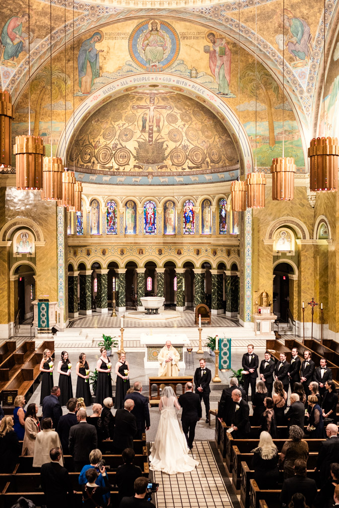 Bride walks down the aisle with her father inside St. Clement Church in Chicago