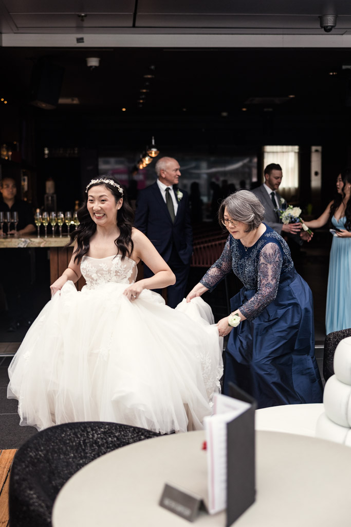 Bride in a white dress is helped with her gown by her mother at The Godfrey Hotel in downtown Chicago