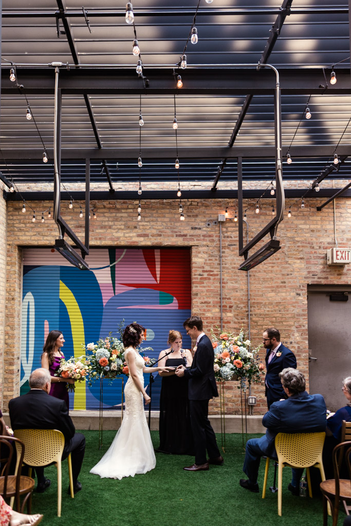 Groom places ring on bride's finger during Ada Street Chicago wedding ceremony