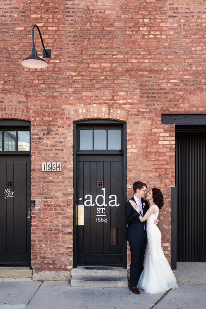 Newlyweds embrace outside Ada Street restaurant during their wedding celebration