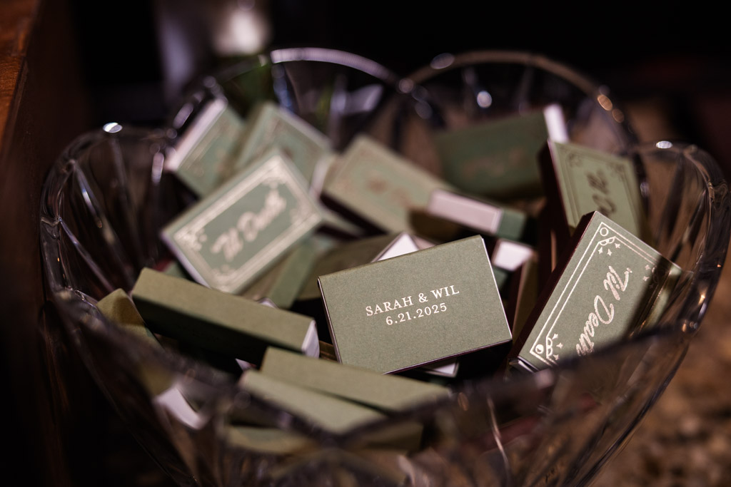 A glass bowl filled with commemorative matchboxes for wedding reception at Ada Street Chicago