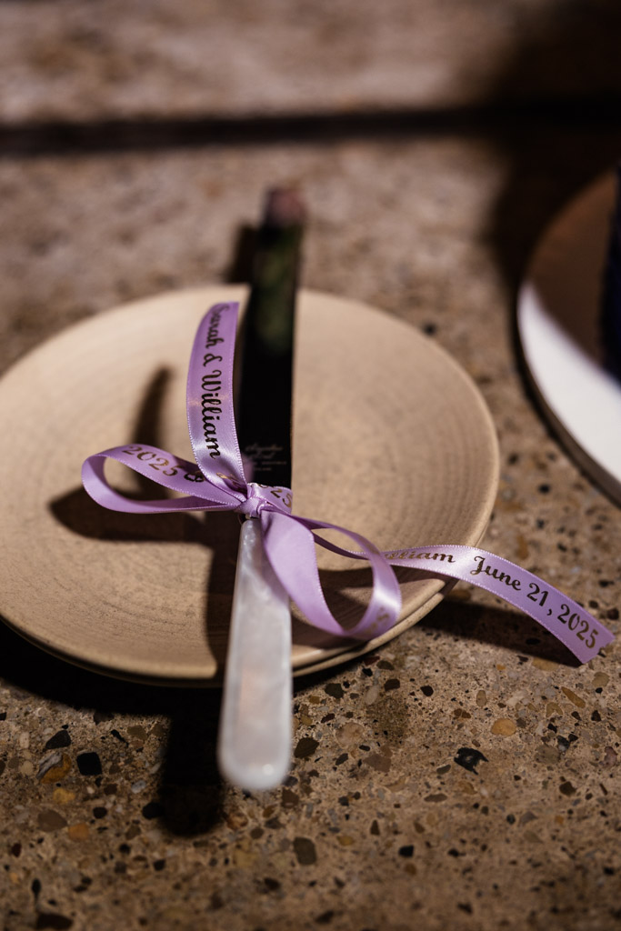 A plate with a cake knife tied with a lavender ribbon for wedding celebration at Ada Street Chicago