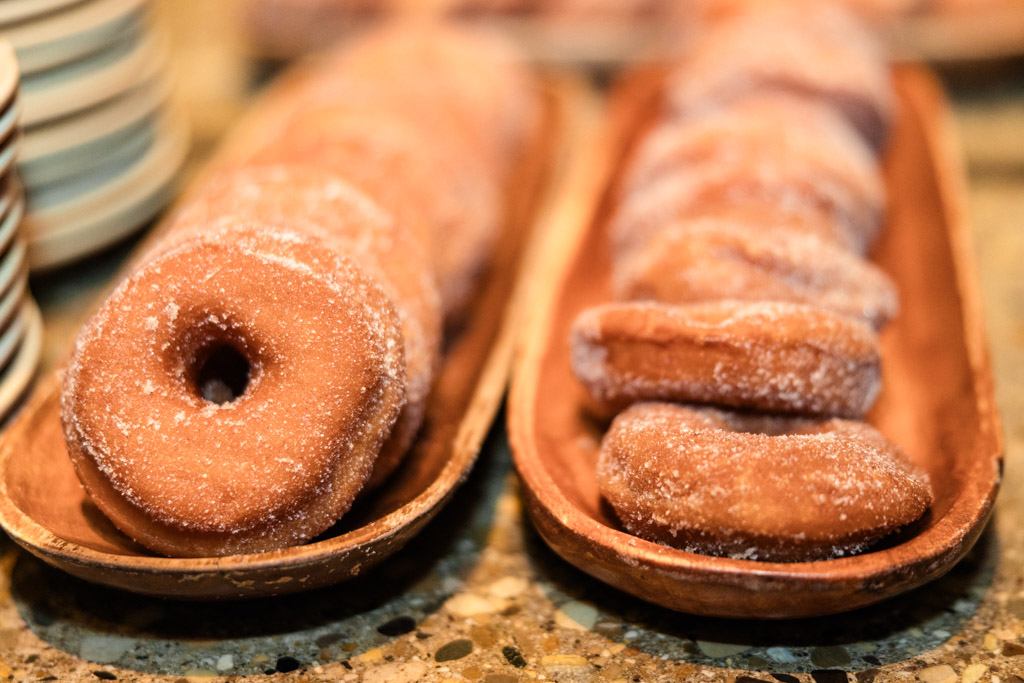 Sugary donuts arranged in two wooden trays on a countertop for Ada Street Chicago wedding reception