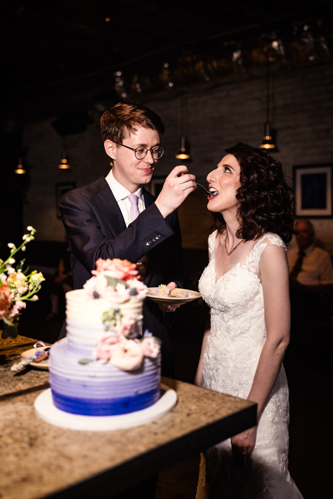 Groom feeds cake to his smiling bride at their Ada Street Chicago wedding reception
