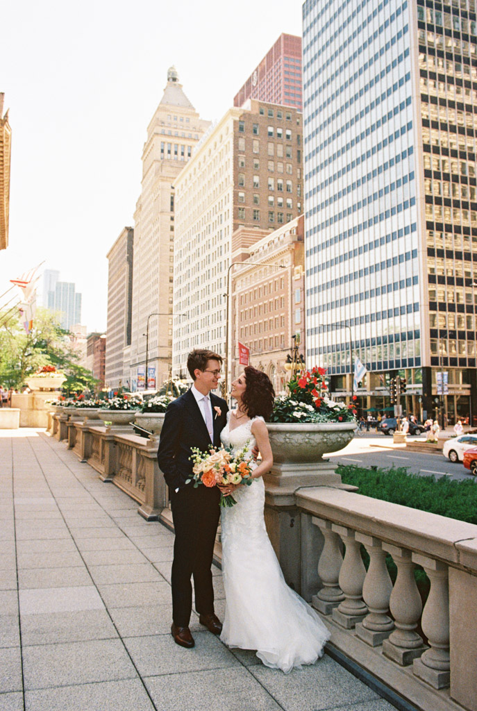 Bride and groom standing in front of Art Institute Chicago with downtown buildings in the background