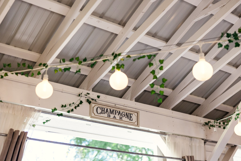 String lights and ivy hang from a white wooden ceiling at Être Farms in St. Joseph, Michigan