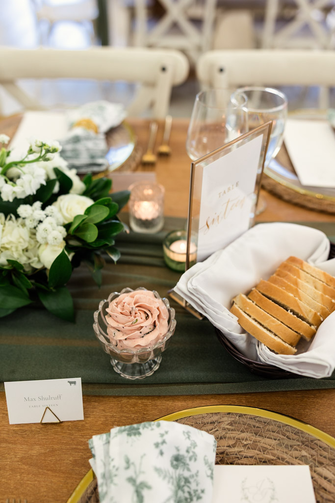 Guest table setting at Être Farms with bread, floral arrangement, and table sign