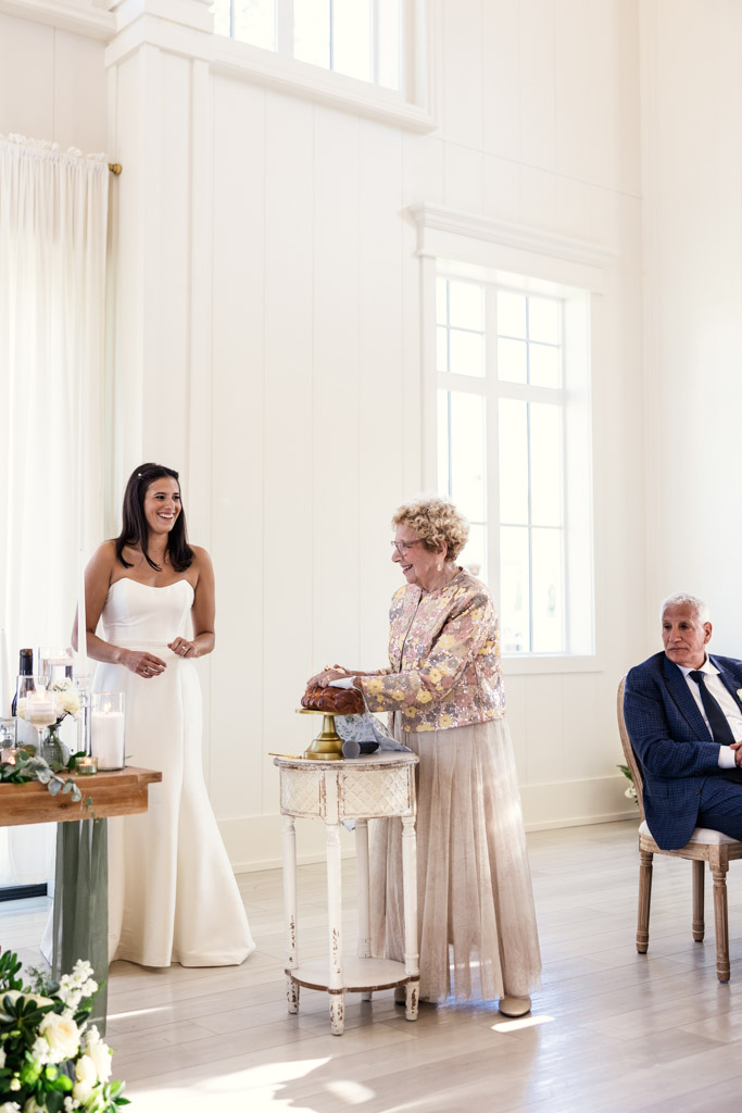 Groom's grandmother cuts the challah during Être Farms wedding reception