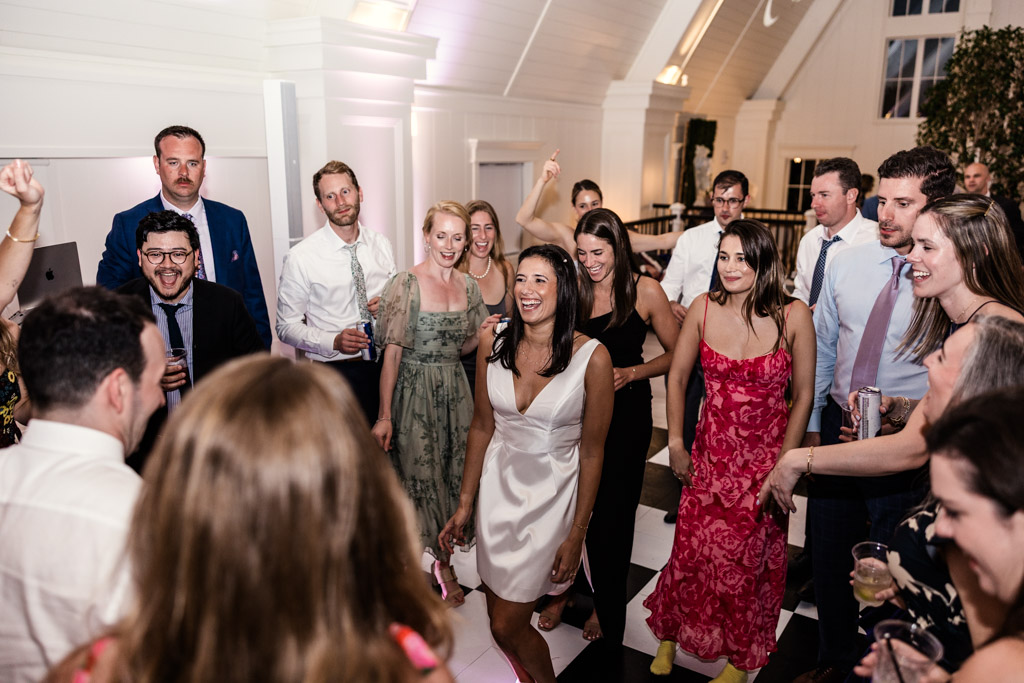 Bride, groom and guests dancing and smiling at Être Farms wedding reception