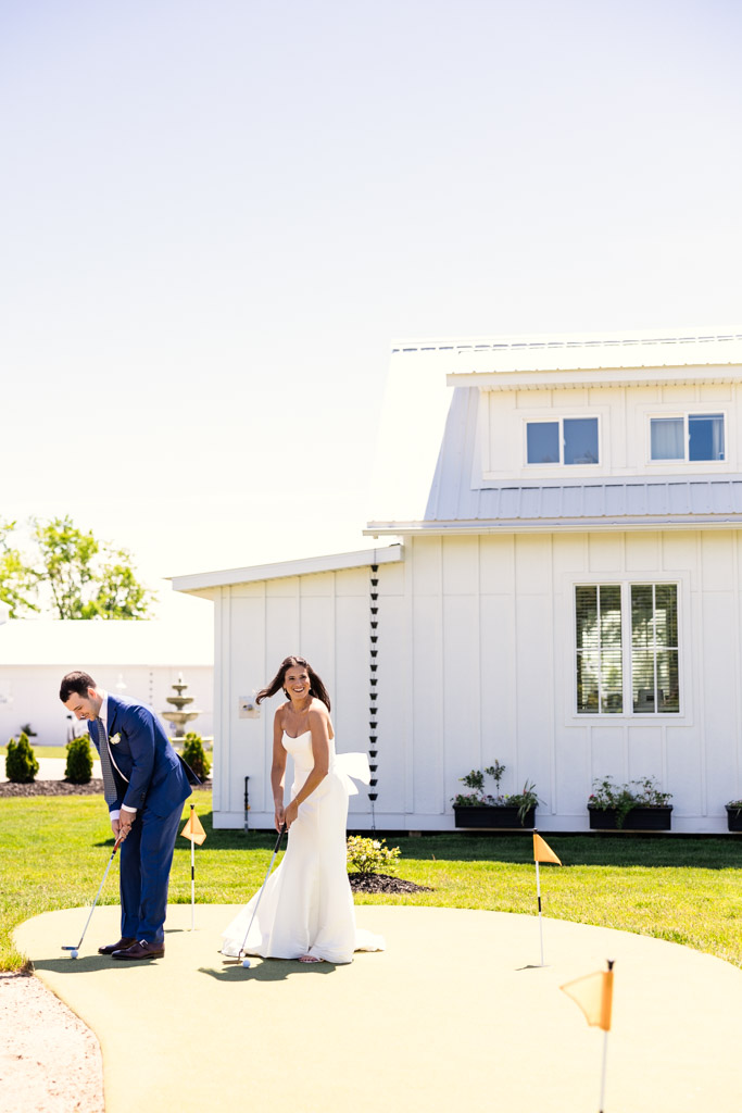 Bride and groom playing mini golf outside Être Farms on a sunny day