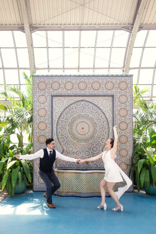 Engaged couple dances in front of Zellij Fountain inside Garfield Park Conservatory