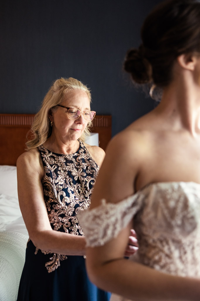 Bride's mother helps bride adjust her dress before Kemper Lakes Golf Club wedding celebration