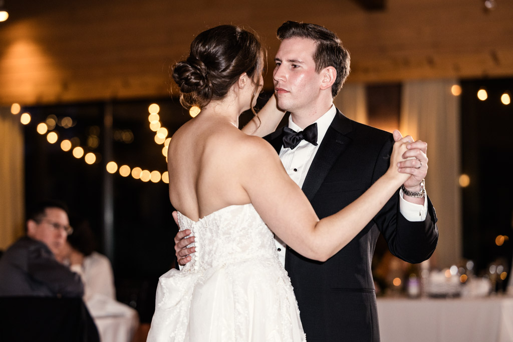 Bride and groom dance during their wedding reception at Kemper Lakes Golf Club, with warm string lights in the background