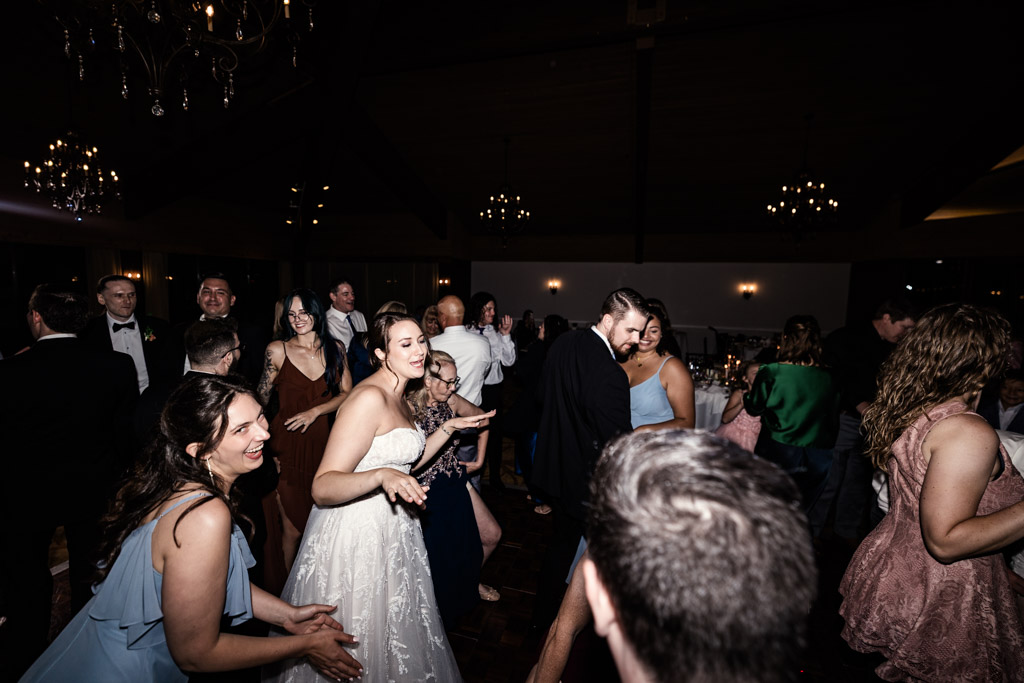 Bride in a white dress dances with guests at wedding reception at Kemper Lakes Golf Club