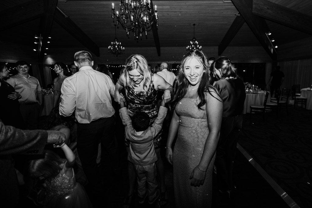 Black and white photo of guests dancing and smiling at Kemper Lakes Golf Club wedding reception