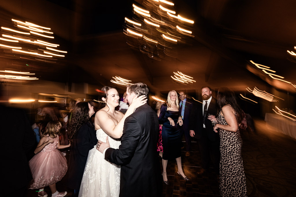 Creative shutter drag photo of bride and groom dancing surrounded by guests at Kemper Lakes Golf Club wedding reception
