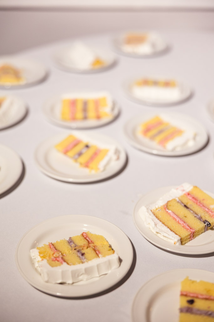 Slices of layered cake with white frosting on white plates, arranged on a table for wedding reception at Kemper Lakes Golf Club