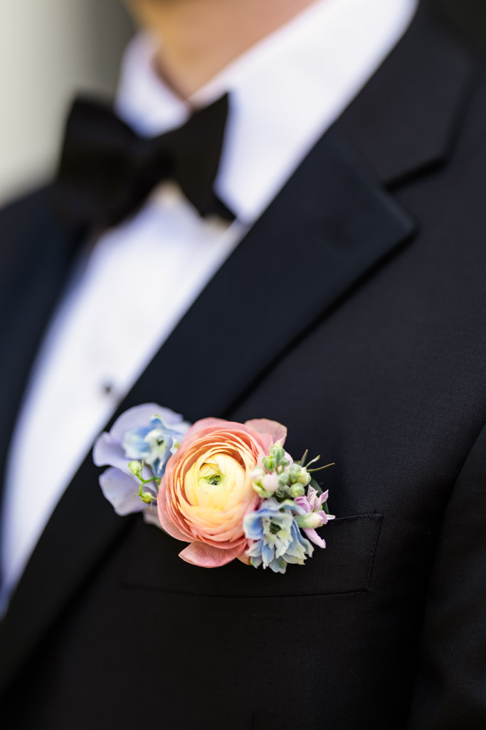 Detail photo of groom's boutonnière pinned to his tuxedo jacket before his Kemper Lakes Golf Club wedding