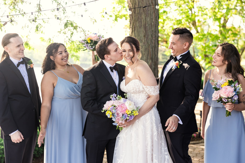 Bride and groom smile and laugh with their wedding party outdoors at Kemper Lakes Golf Club