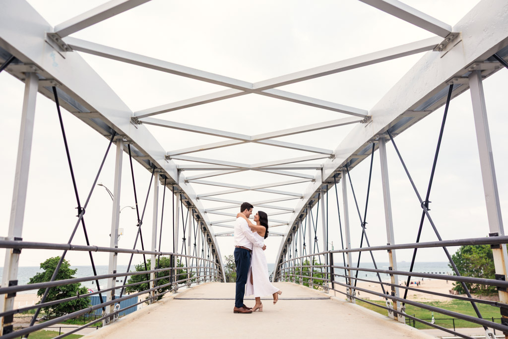 Couple embraces on a metal pedestrian bridge during Lincoln Park engagement session