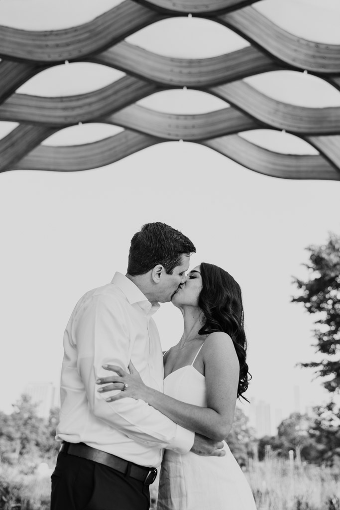 Black and white photo of couple kissing outdoors under the Honeycomb during Lincoln Park engagement session