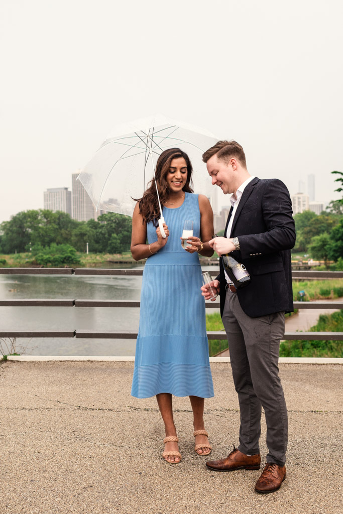 A woman holding an umbrella and a man pouring a drink in Lincoln Park on a cloudy Chicago day