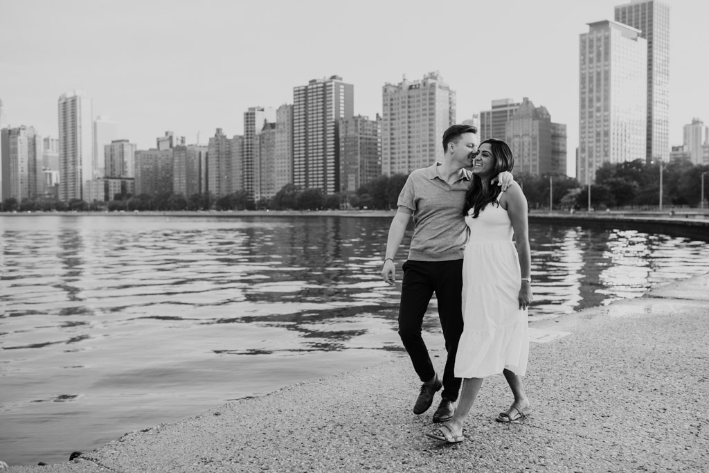 Black and white photo of couple walking by the edge of Lake Michigan at North Avenue Beach during their Chicago summer engagement session
