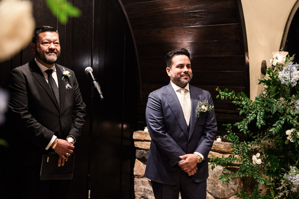 Groom and officiant stand at the front of wedding ceremony at Osteria Via Stato