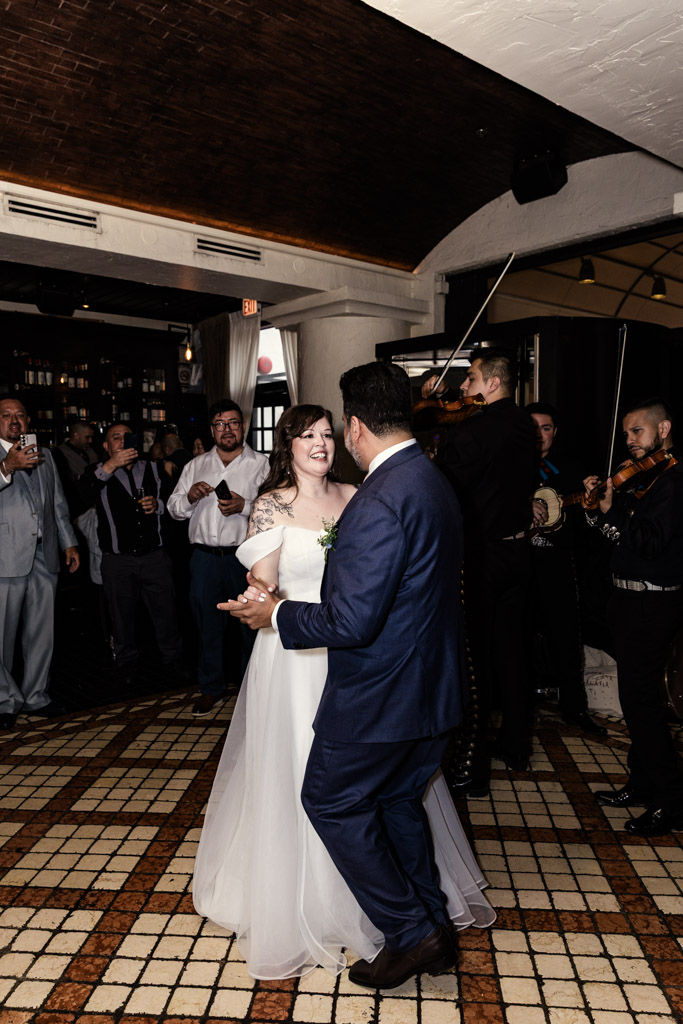 A bride and groom dance together while a Mariachi EDC plays at their Osteria Via Stato wedding reception